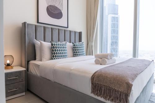 1 dormitorio con 1 cama grande y ventana grande en Heaven Crest Holiday Homes - Luxury Forte en Dubái