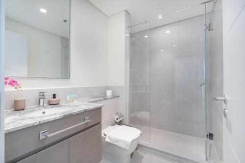 uma casa de banho com um chuveiro, um WC e um lavatório. em Heaven Crest Holiday Homes - Luxury Forte em Dubai