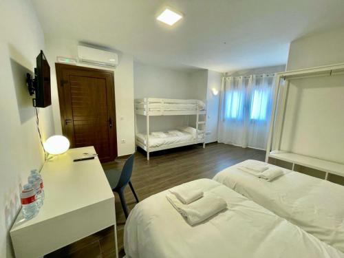 um quarto de hotel com duas camas e uma secretária e um quarto com duas camas em Hostería La milla Rural 