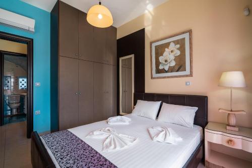 a bedroom with a bed with two white towels on it at Paramithia Villa in Afantou