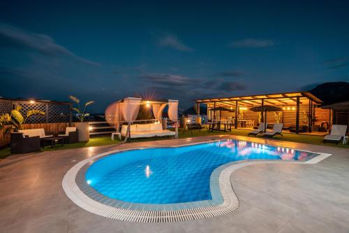 una piscina en un patio por la noche en Paramithia Villa, en Afantou