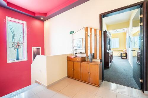 a living room with red walls and a mirror at Paramithia Villa in Afantou