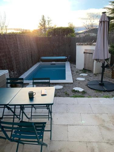 un patio avec une table et des chaises et une piscine dans l'établissement Maison de charme à Lourmarin, à Lourmarin