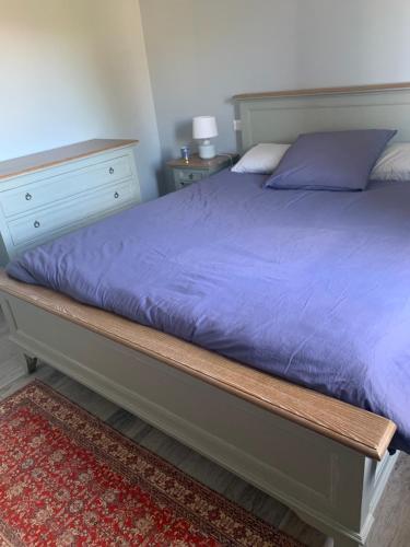 - un lit avec une couette violette dans l'établissement Maison de charme à Lourmarin, à Lourmarin