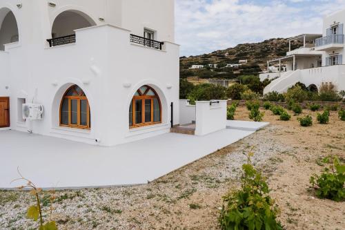 a white house with orange doors and a yard at Orkos Naxian Wave 3 in Mikri Vigla