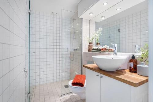 a bathroom with a sink and a toilet and a shower at Prime Location: Spacious & Central in Oslo