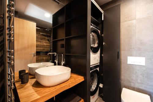 y baño con lavabo y lavadora. en Ski&Bike horský apartmán 502, en Janske Lazne