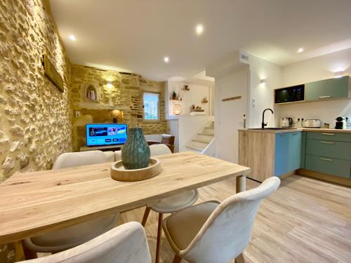 a kitchen and dining room with a wooden table and chairs at Montignac-Lascaux - Les Pierres De Lascaux in Montignac