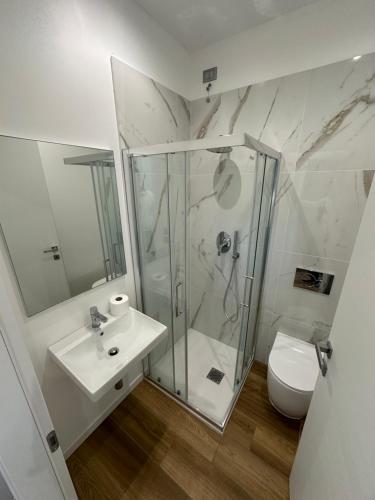 W łazience znajduje się prysznic, umywalka i toaleta. w obiekcie Marina Dream Beach Apartments with Sea View Terrace - Agenzia Cocal w Caorle