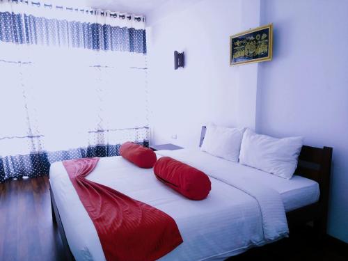 una camera da letto con un letto con cuscini rossi di Discovery Retreat Blackwood a Beragala