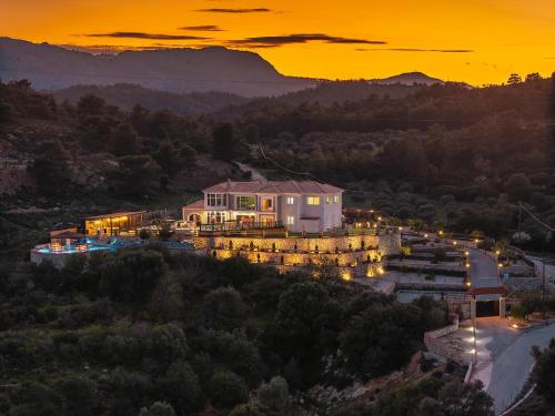a house on a hill with a sunset in the background at Paramithia Villa in Afantou