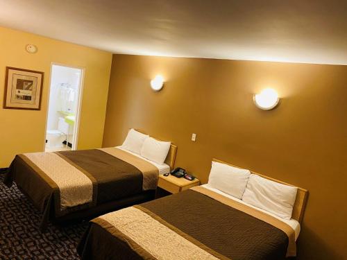 a hotel room with two beds and lights on the wall at M Star Hotel Mansfield in Mansfield