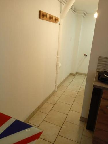 Cette chambre dispose d'un mur blanc et de carrelage. dans l'établissement studio en rez-de-jardin, à Gien