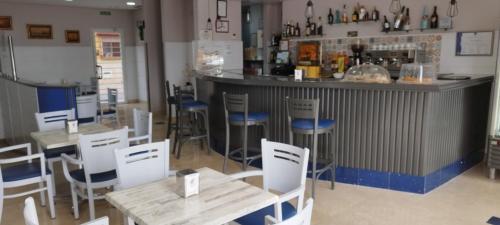 a restaurant with tables and chairs and a bar at Hotel Miraya Beach in Torre del Mar