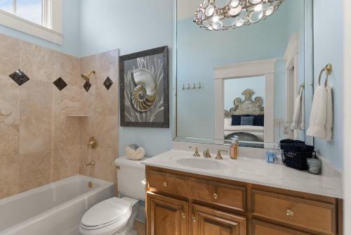 een badkamer met een wastafel, een toilet en een spiegel bij Sea-Esta - 1136 Postell in East End