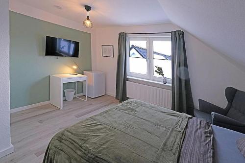 a bedroom with a bed and a desk and a window at *mod. Wohnung in DEL bei Bremen* in Delmenhorst