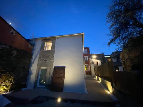 a white house with a door on a street at night at dpCristal Centro Histórico in Sarria