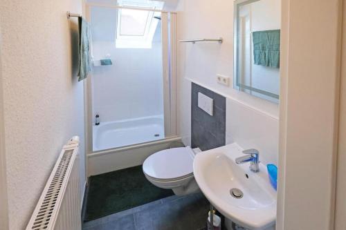 ein weißes Bad mit einem WC und einem Waschbecken in der Unterkunft *mod. Wohnung in DEL bei Bremen* in Delmenhorst