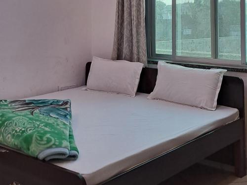 Una cama con dos almohadas encima. en Hotel khatushyamji palace en Khātu