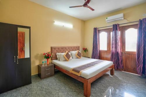 a bedroom with a large bed with purple curtains at Golden Studio Apartment Goa in Calangute