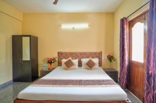 a bedroom with a bed and a window at Golden Studio Apartment Goa in Calangute