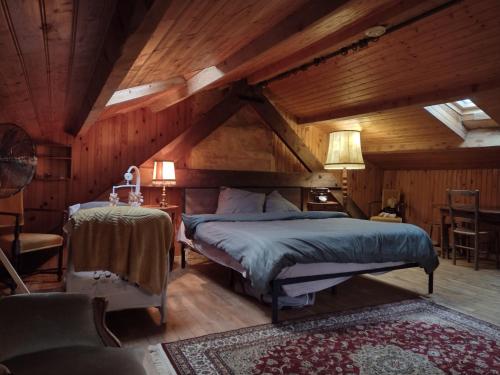 a bedroom with a bed in a room with wooden ceilings at A La Maison des Oiseaux in Saint-Avit-Sénieur