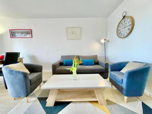 - un salon avec deux chaises bleues et une table basse dans l'établissement Appartement Duplex - Proche Plage, à Carnac