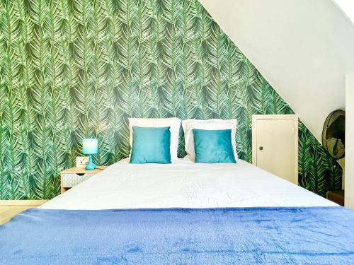 une chambre avec un grand lit avec des oreillers bleus dans l'établissement Appartement Duplex - Proche Plage, à Carnac