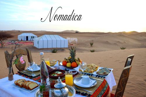 a table with food on it in the desert at Nomadica Luxury Camp in Merzouga