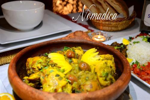 a bowl of food on a table with rice at Nomadica Luxury Camp in Merzouga