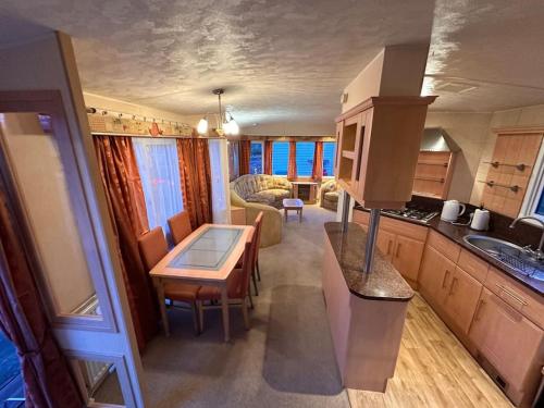 a kitchen and living room with a table in a house at Atlas 2 Bedroom Caravan, Glasgow in Uddingston
