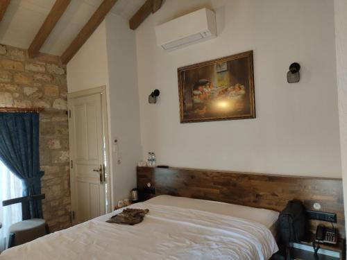 a bedroom with a bed and a painting on the wall at EFLIN HAUS Historical Place & Monument in Cesme