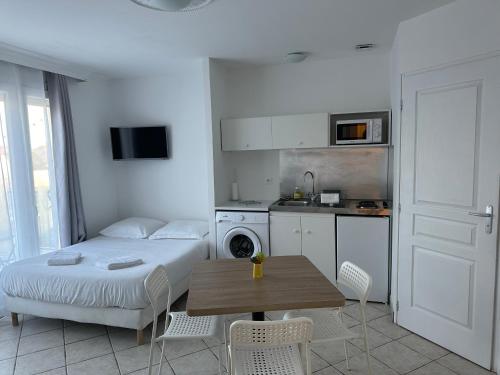 une chambre avec un lit et une table et une cuisine dans l'établissement Le charme de la Touraine, à Fondettes