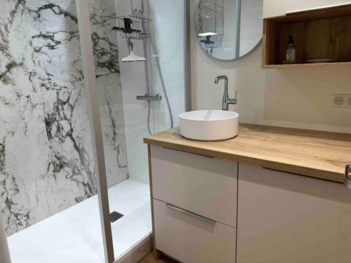 une salle de bain blanche avec un lavabo et une douche dans l'établissement Appartement Val Malo, à Dinard