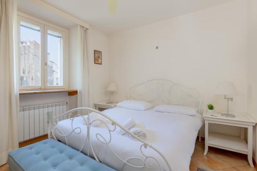 a bedroom with a white bed and a blue bench at Suite Calvino, in Piazza Unità con parcheggio in Trieste