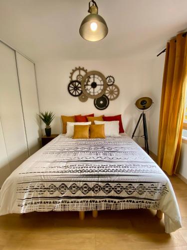 - une chambre avec un grand lit et une horloge murale dans l'établissement Loft Industriel à côté de La Défense, à Nanterre