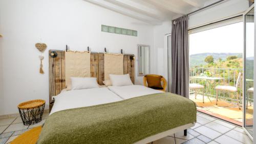 1 dormitorio con 1 cama grande y balcón en Casa la Quinta, en Ríogordo