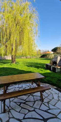 un banc en bois assis sur un patio en pierre avec un arbre dans l'établissement 