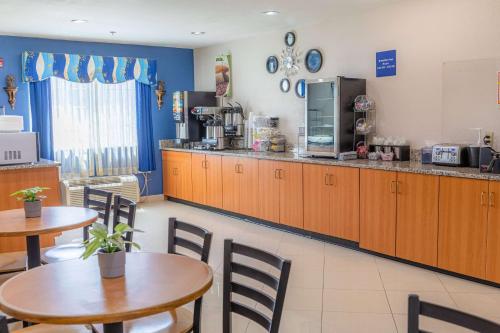 a restaurant with two tables and a counter with a kitchen at Microtel Inn & Suites by Wyndham Kingsland Naval Base I-95 in Kingsland