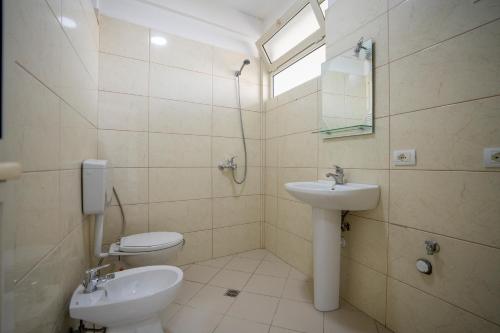 een badkamer met een wastafel en een toilet bij Golden Sleep Hostel in Shkodër