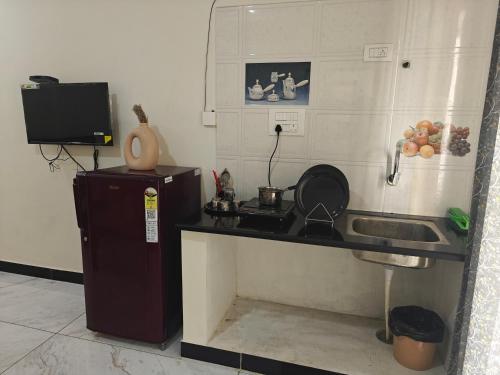 La cuisine est équipée d'un comptoir, d'un évier et d'un réfrigérateur. dans l'établissement The Whispering Willows, à Mysore