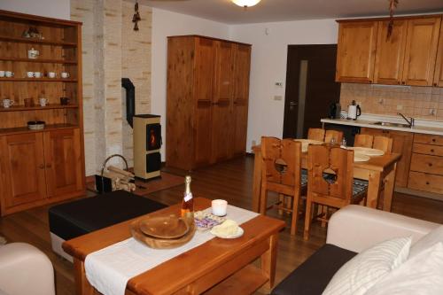 ein Wohnzimmer mit einem Tisch und einer Küche in der Unterkunft Vila Pohoda Javorníky s rozľahlým pozemkom in Makov