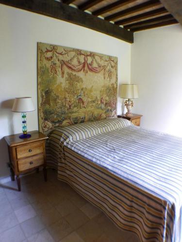 a bedroom with a bed with a painting on the wall at Private Villa Dolce Vita in Lucignano