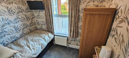 a small bedroom with a bed and a window at Brooke House in Shanklin
