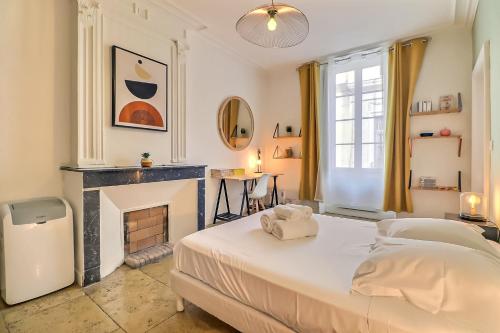 - une chambre avec un lit et une cheminée dans l'établissement Le Magdalena - Confort 4* en plein écusson, à Nîmes