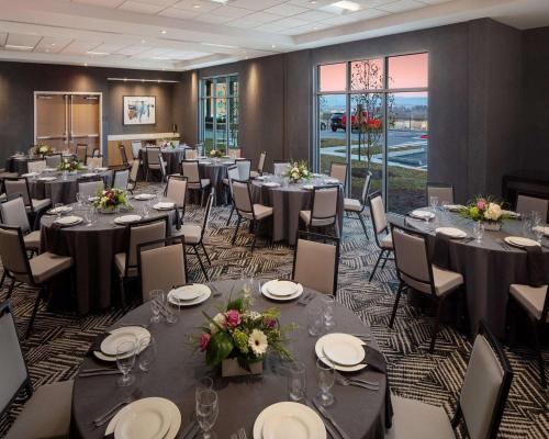 a banquet room with tables and chairs with flowers at Hyatt Place Harrisonburg in Harrisonburg