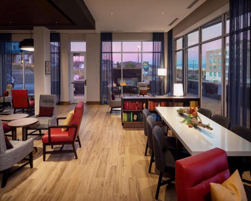 a waiting room with chairs and tables and windows at Hyatt Place Harrisonburg in Harrisonburg