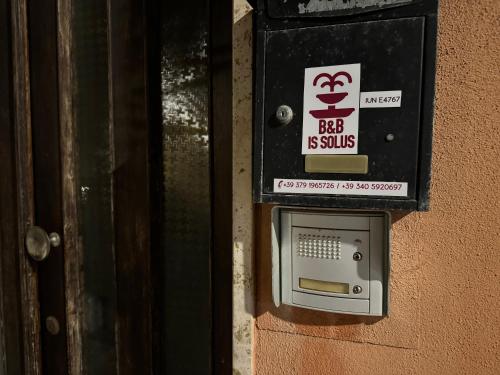 budka telefoniczna na boku budynku w obiekcie Domo Is Solus w mieście SantʼAntìoco