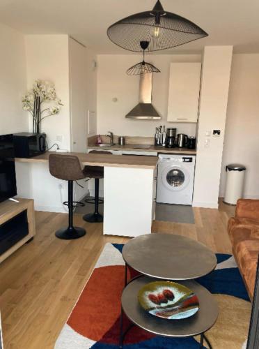 a kitchen and living room with a table and a counter at Very nice and quiet 38 m in Suresnes with parking in Suresnes
