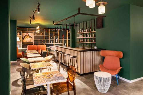 un restaurante con paredes verdes, mesas y sillas en Quadro Hotel, Trademark Collection by Wyndham, en San Julián